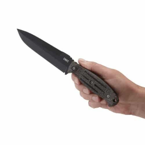 Hand holding a CRKT fixed knife with a black blade and textured handle, ideal for camping and outdoor use.