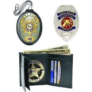 Collection of badges including a firefighter badge, police badge, and a badge wallet with cash and cards.