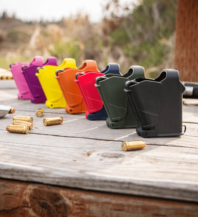 Colorful gun magazines loaders and bullets on a wooden surface with a natural background