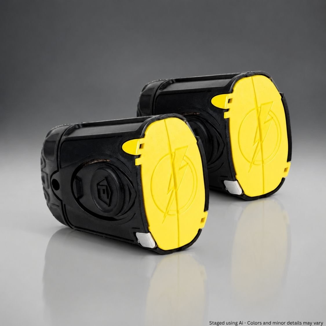 Black and yellow Taser cartridges on a reflective surface with a gray background