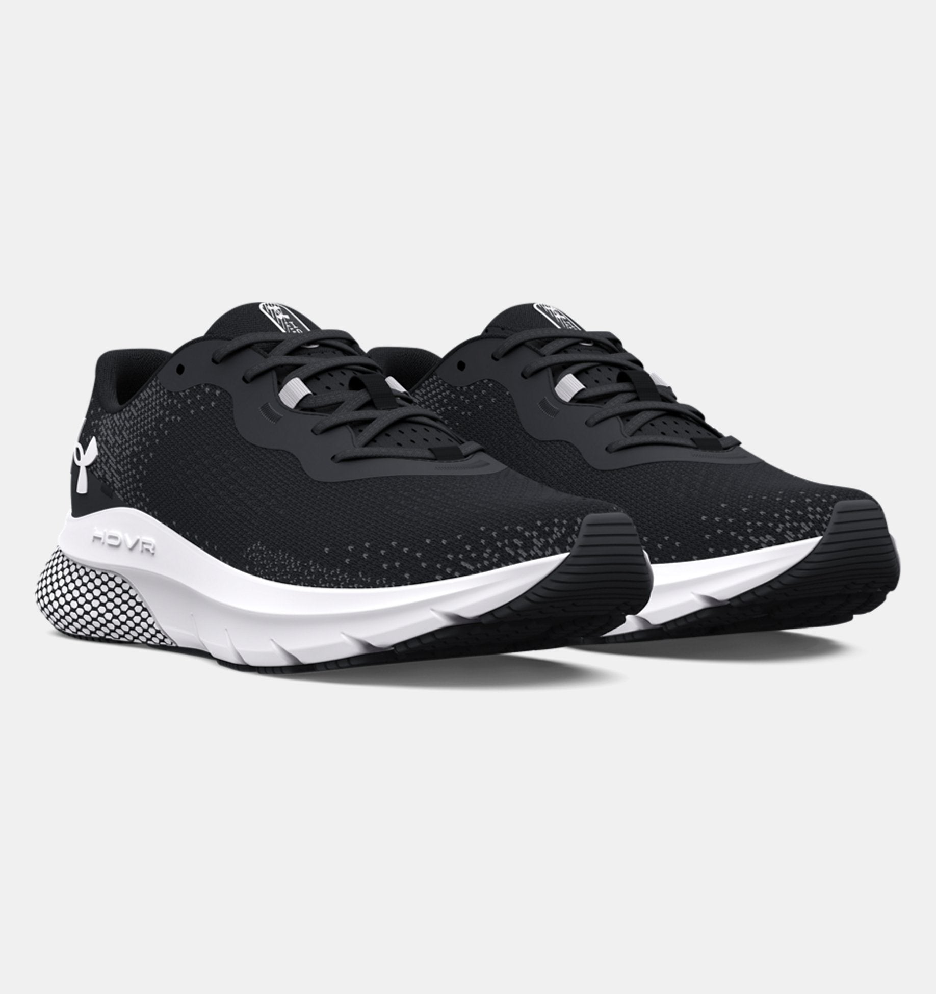 Black running shoes with white soles on a light gray background