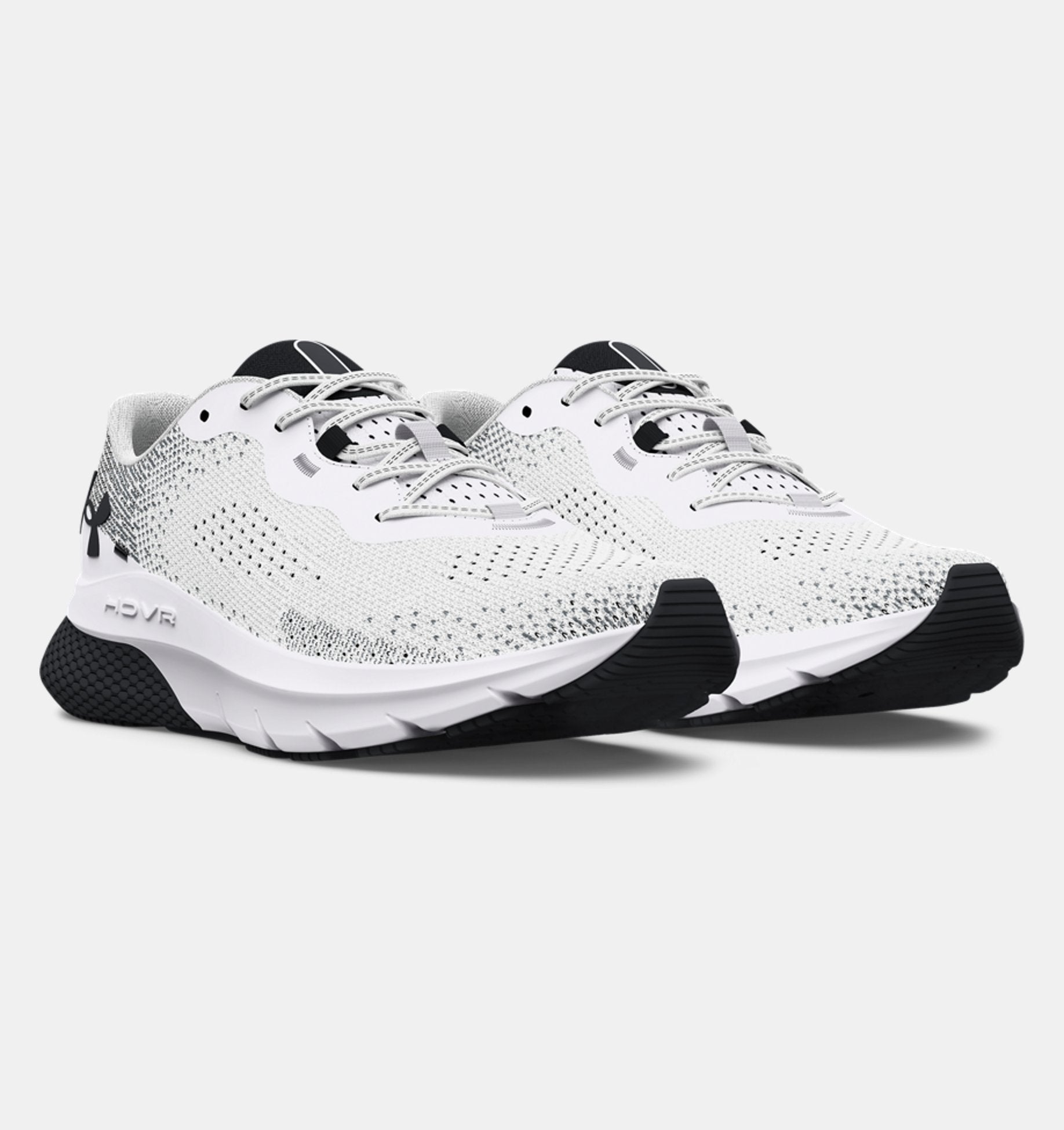 White running shoes with black soles on a light gray background