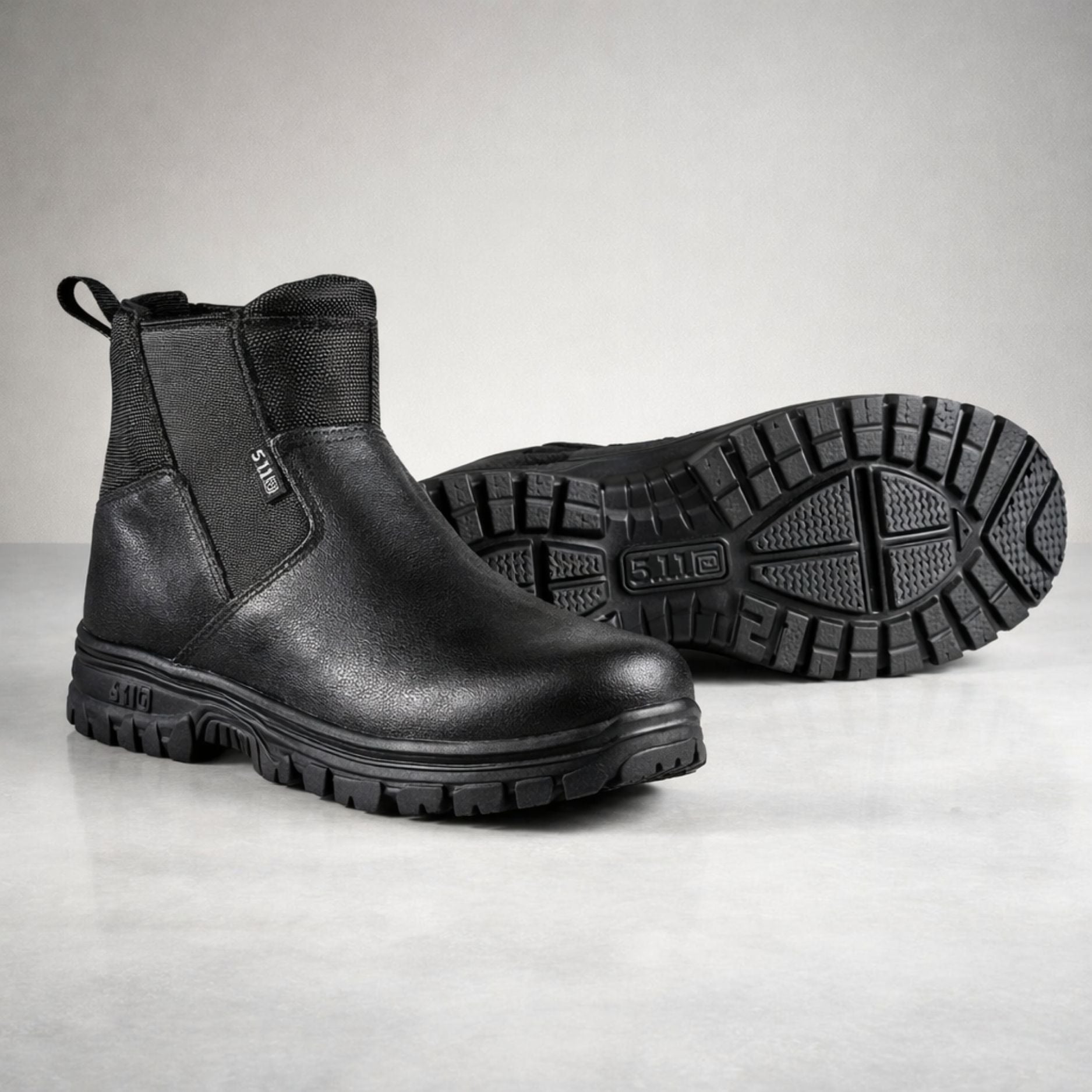 Pair of black boots on a light gray background