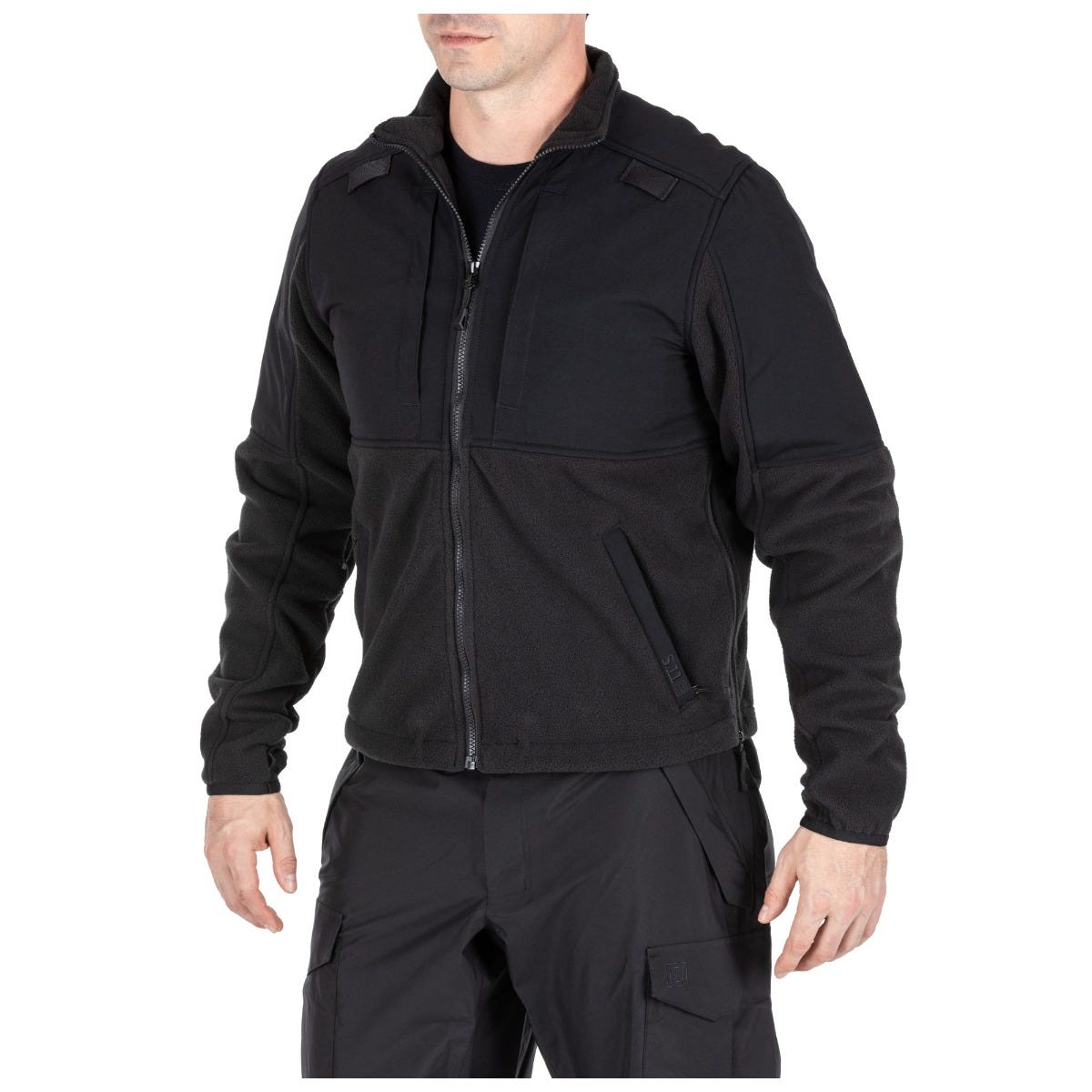 Person wearing a black tactical jacket on a white background