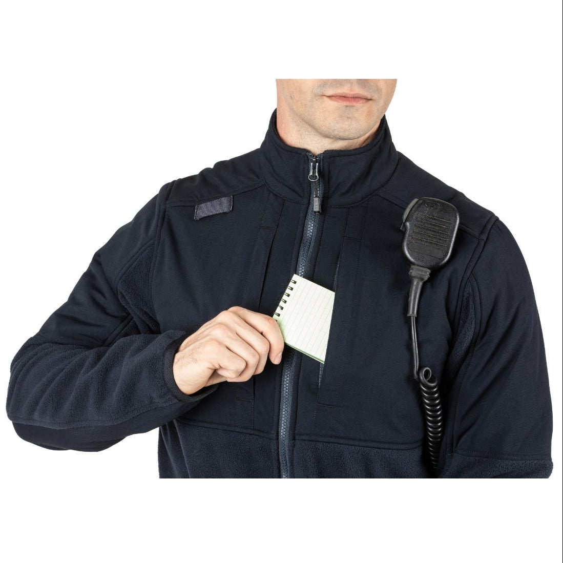 Person wearing a black jacket with a walkie-talkie attached, holding a notepad.