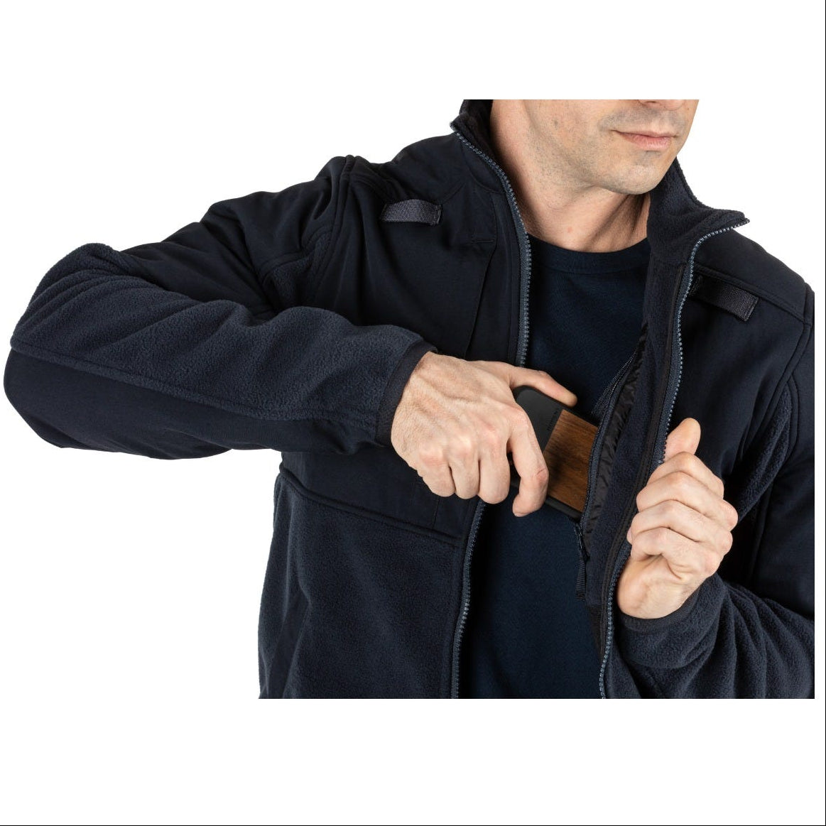 Person wearing a dark blue jacket with a phone in the pocket on a white background