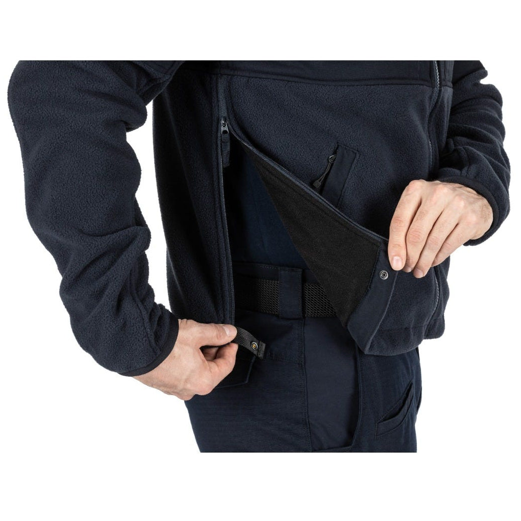 Person wearing a dark blue jacket with a front pocket on a white background