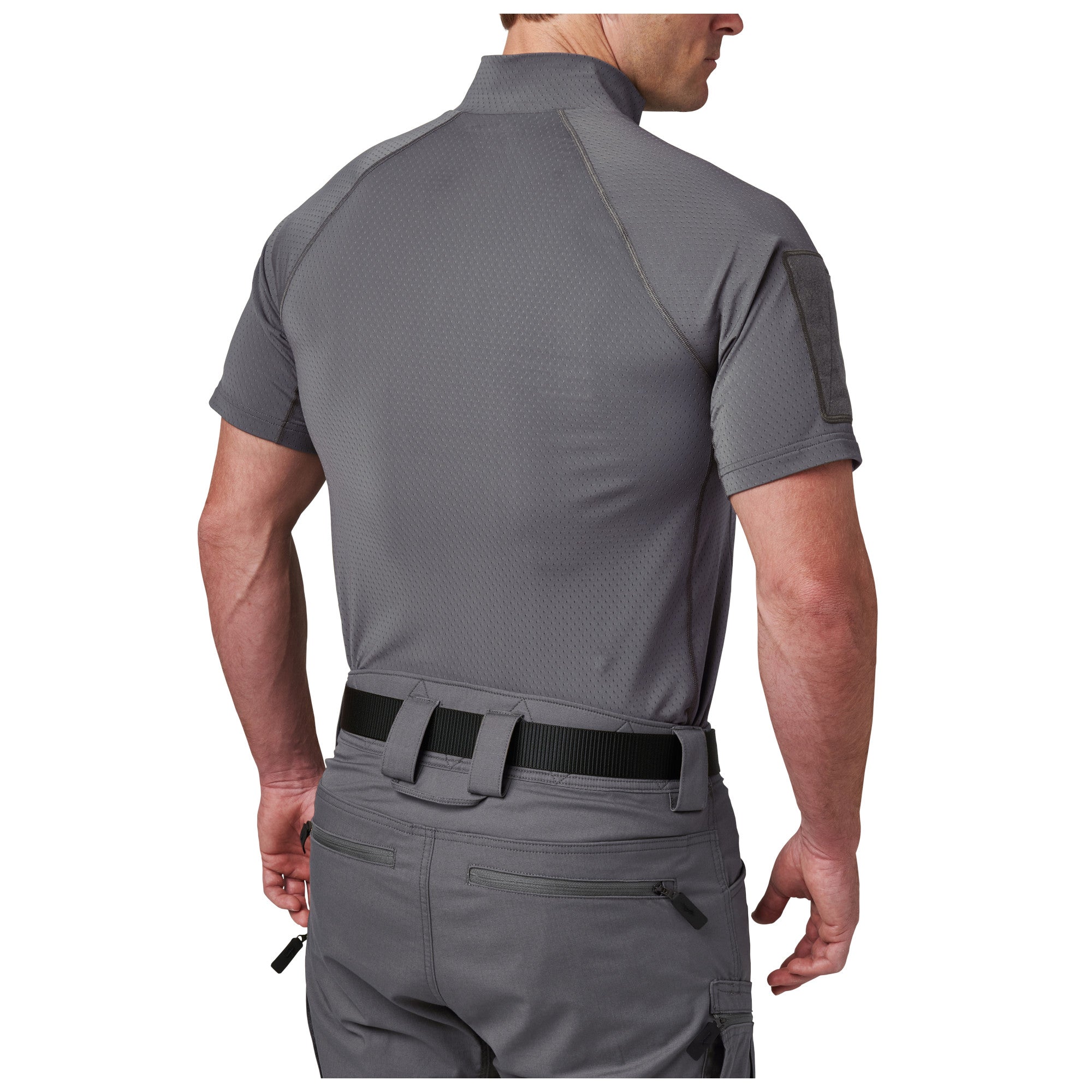 Person wearing a gray tactical shirt and pants on a white background