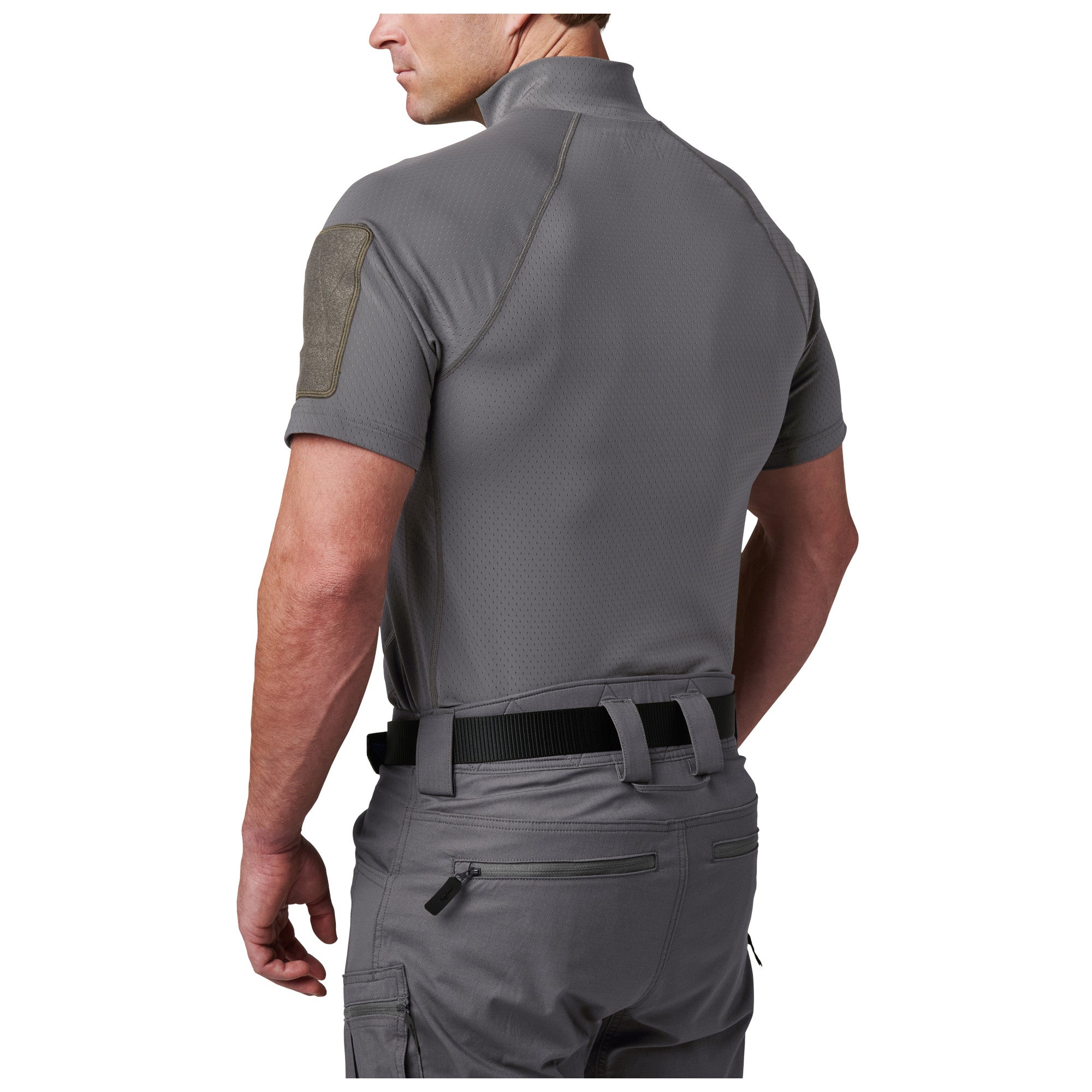 Person wearing a gray tactical shirt and pants on a white background
