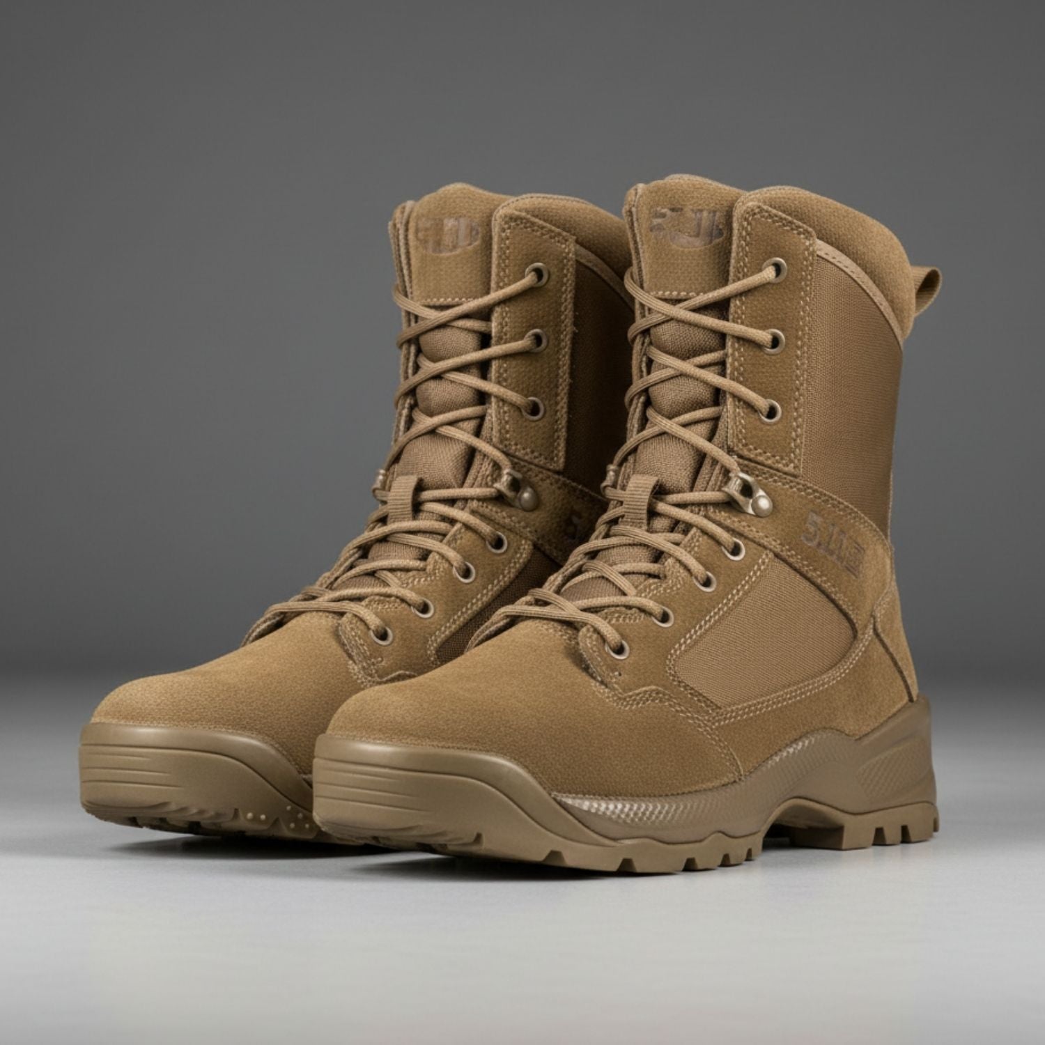 Pair of tan tactical boots on a gray background
