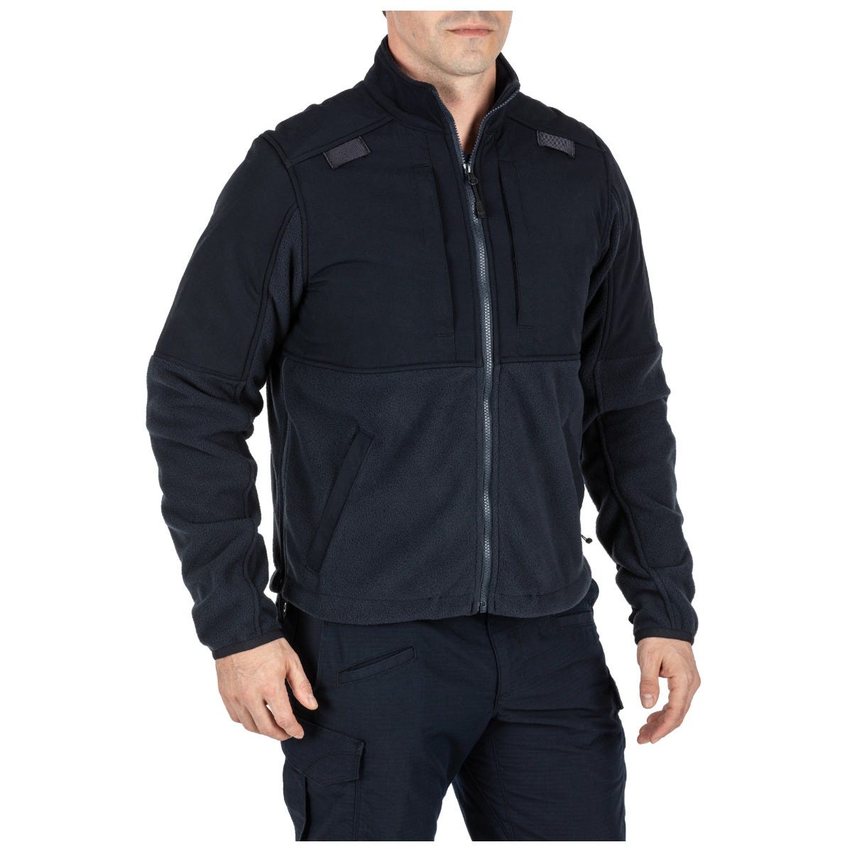 Person wearing a black tactical jacket on a white background
