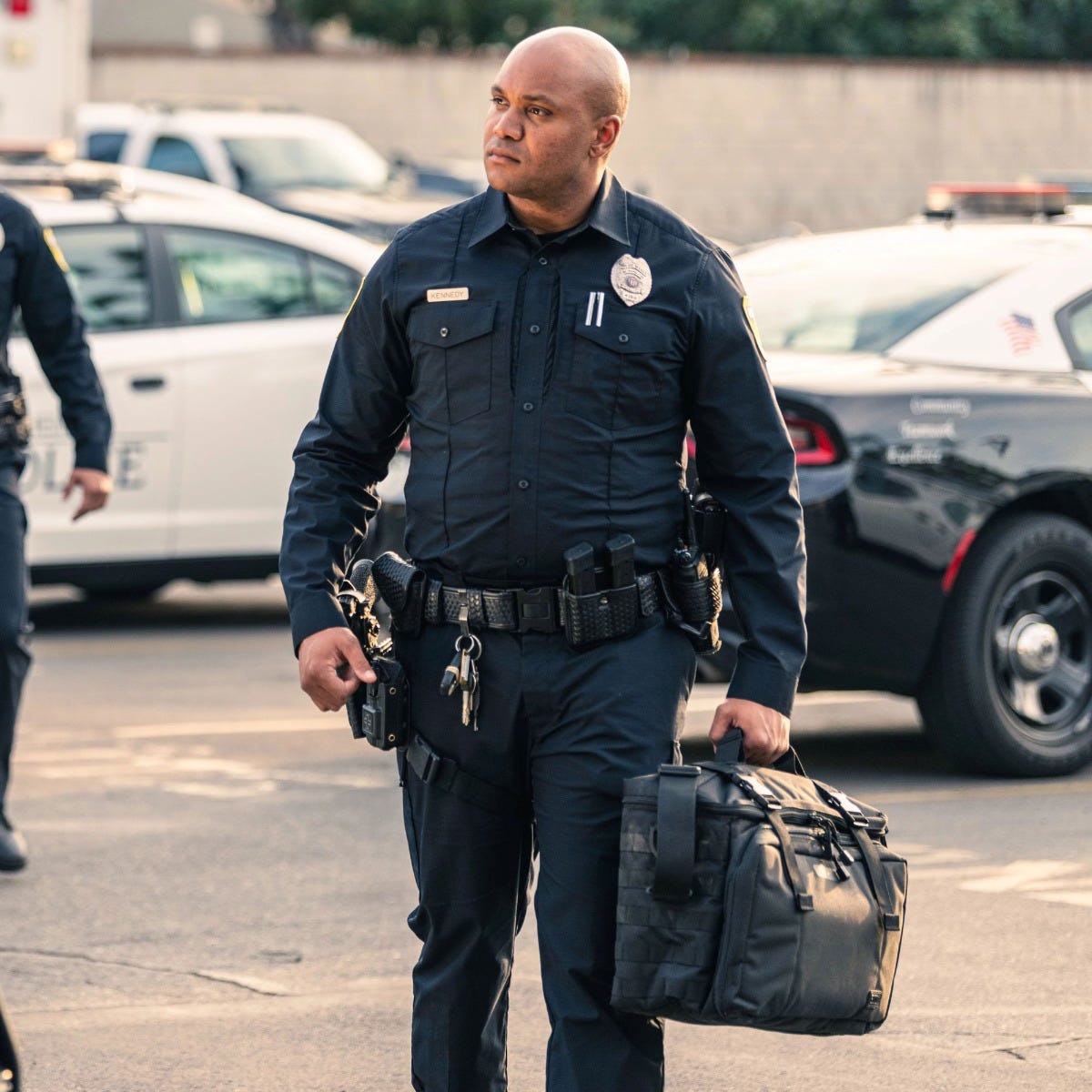 Police Officer carrying a 5.11 Tactical Wingman Patrol Bag Seat Organizer black duty gear bag