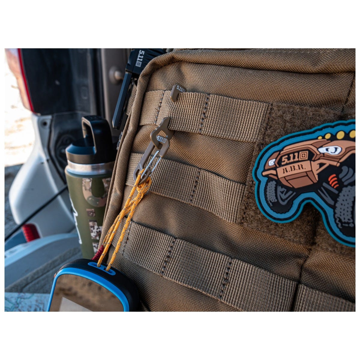 Brown tactical backpack with a patch in a vehicle interior