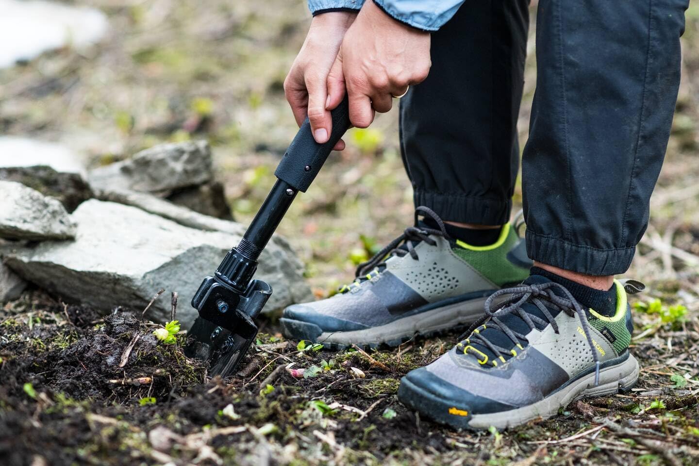 User digging into the soil with a Gerber Gear Gorge Folding Shovel, showcasing its versatility for outdoor adventures.