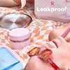 Woman relaxing on a picnic blanket with Hydro Flask products, showcasing the leakproof feature of the food jar.