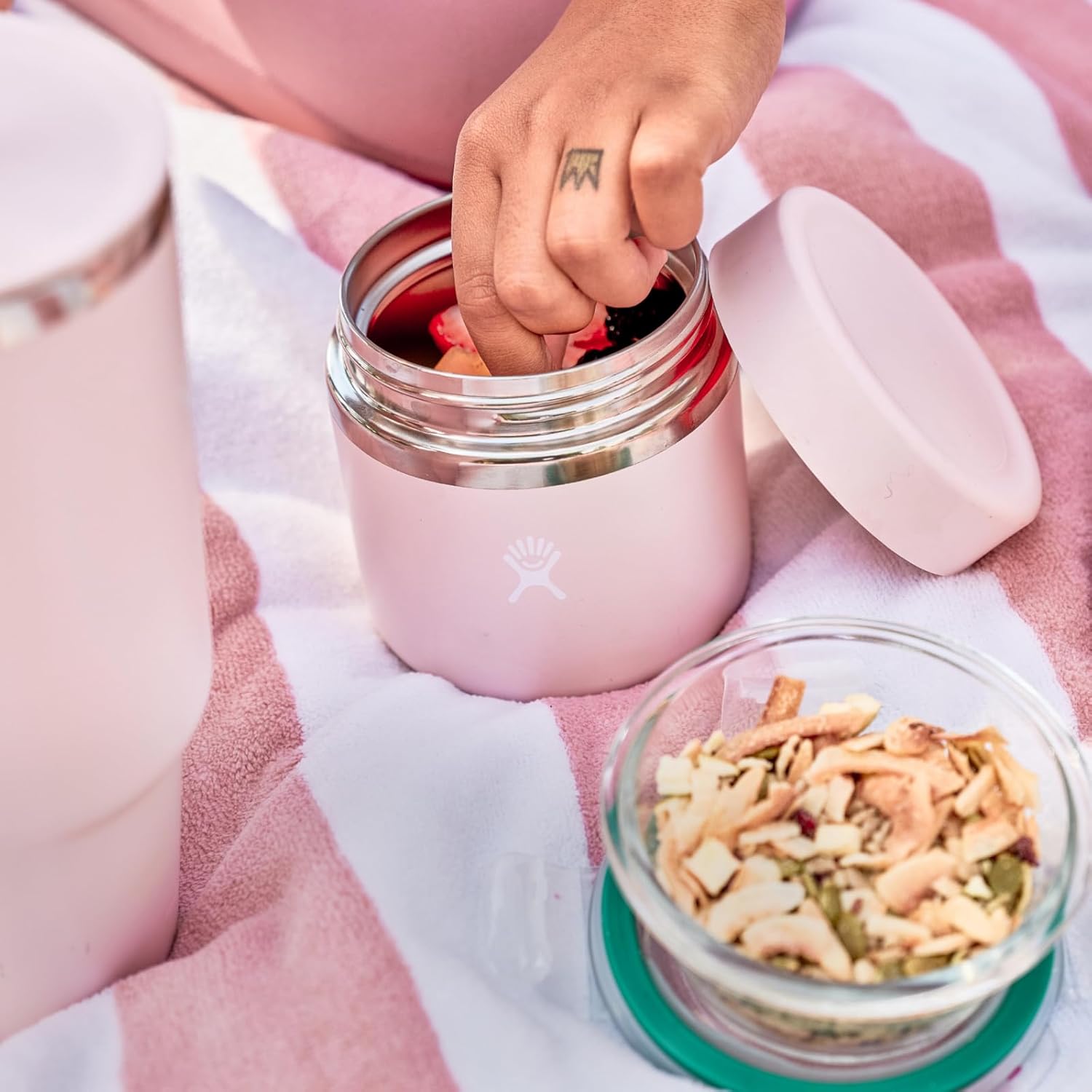 Person reaching into a Hydro Flask 12 oz insulated food jar, perfect for keeping meals fresh during outdoor adventures.