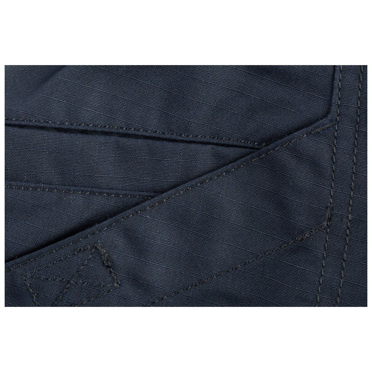 Close-up of dark blue fabric with stitching detail on a white background