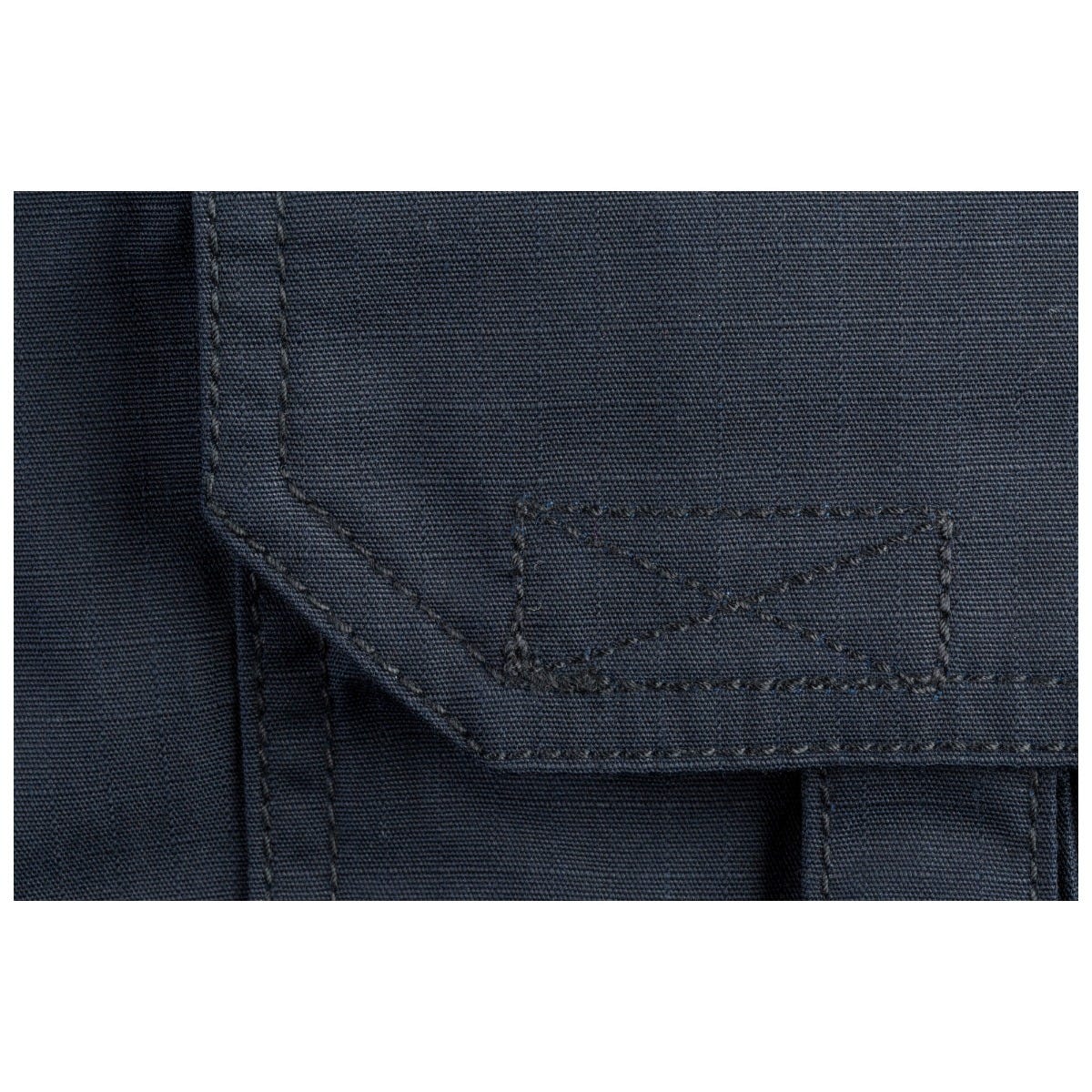 Close-up of a dark blue fabric with stitching detail on a white background