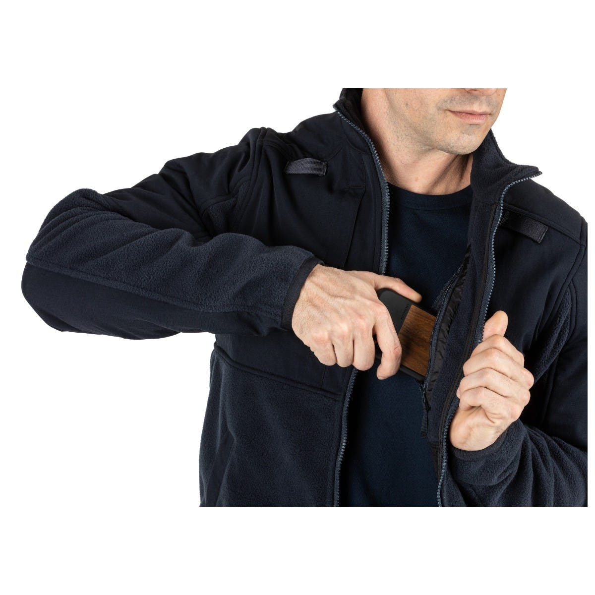 Man wearing 5.11 Tactical Fleece 2.0, drawing a concealed item from the chest pocket. Perfect for cold weather readiness.