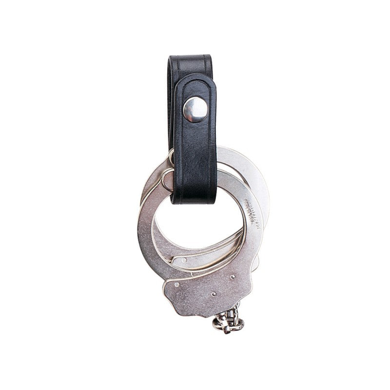 Aker Leather Handcuff Strap holding silver handcuffs, crafted from premium vegetable-tanned leather with solid brass snap.
