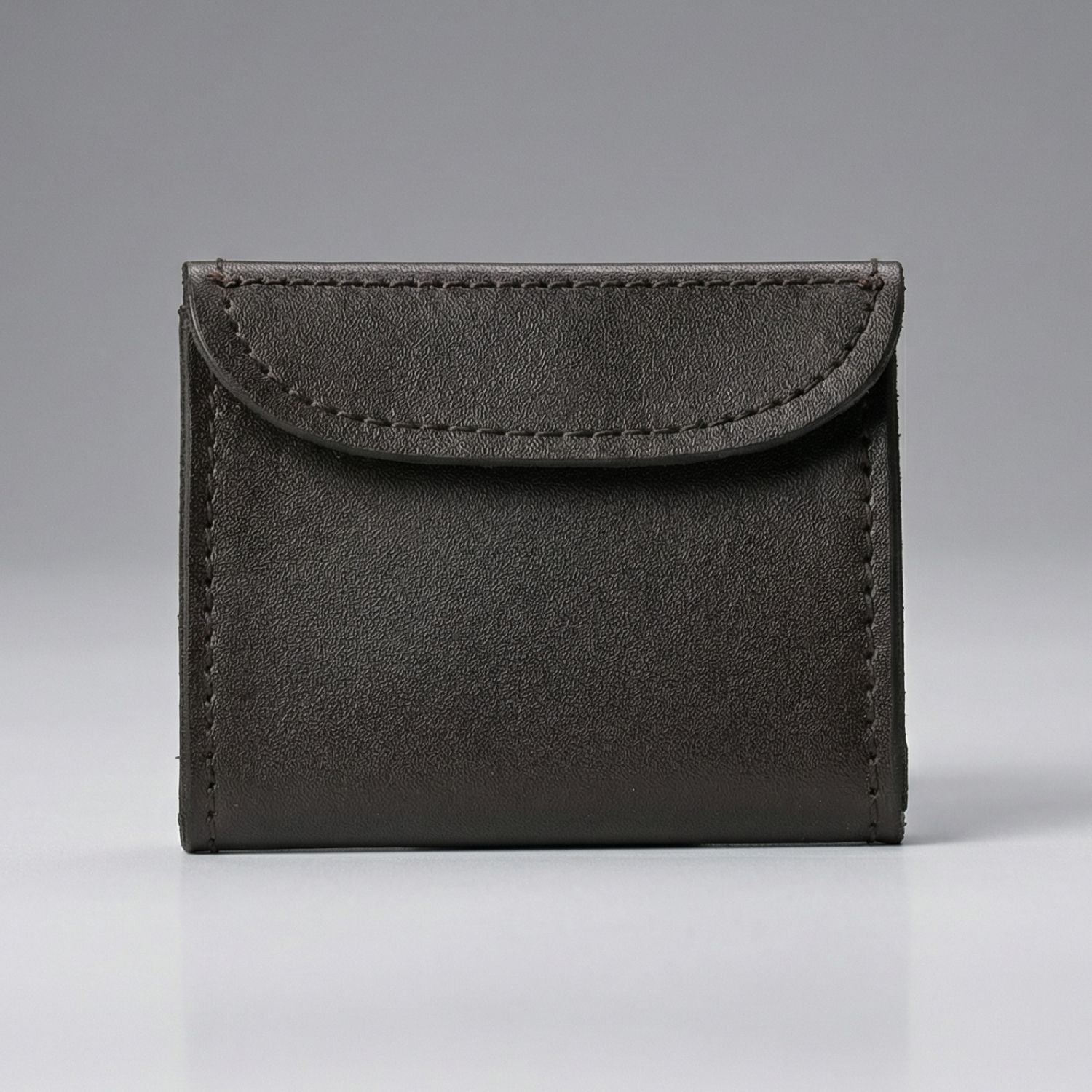 Black leather disposable glove holder on a gray background