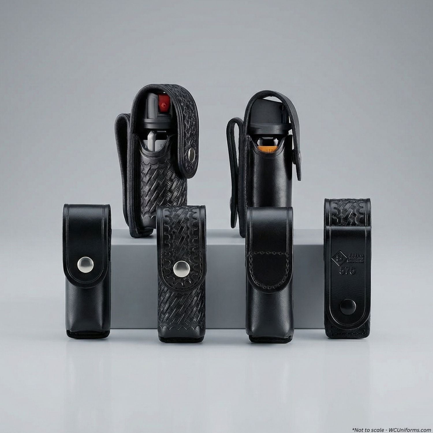 Set of black leather holsters on a gray background