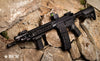 BCM rifle positioned on rocky terrain, showcasing tactical features and accessories for enhanced performance and versatility.