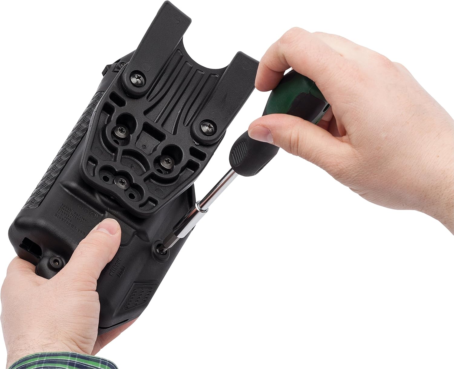 Person using a screwdriver to adjust a black tactical device on a white background