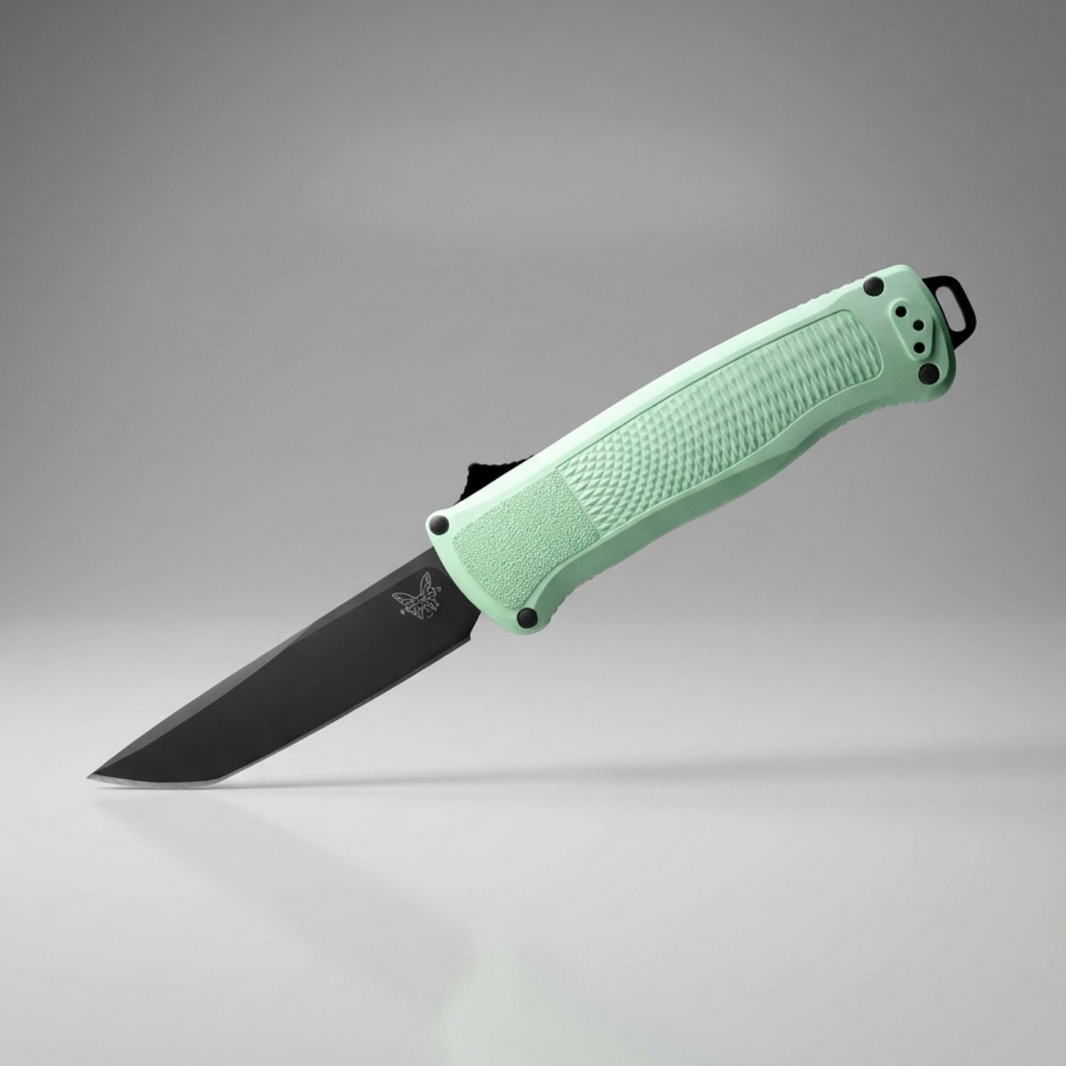 Green folding knife with black blade on a gray background
