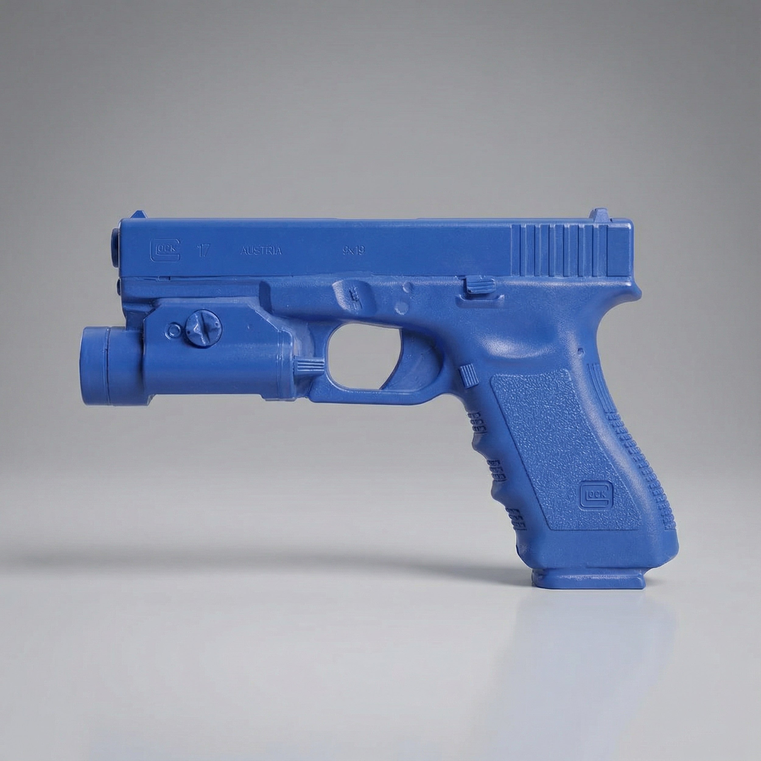 Blue plastic gun model on a gray background