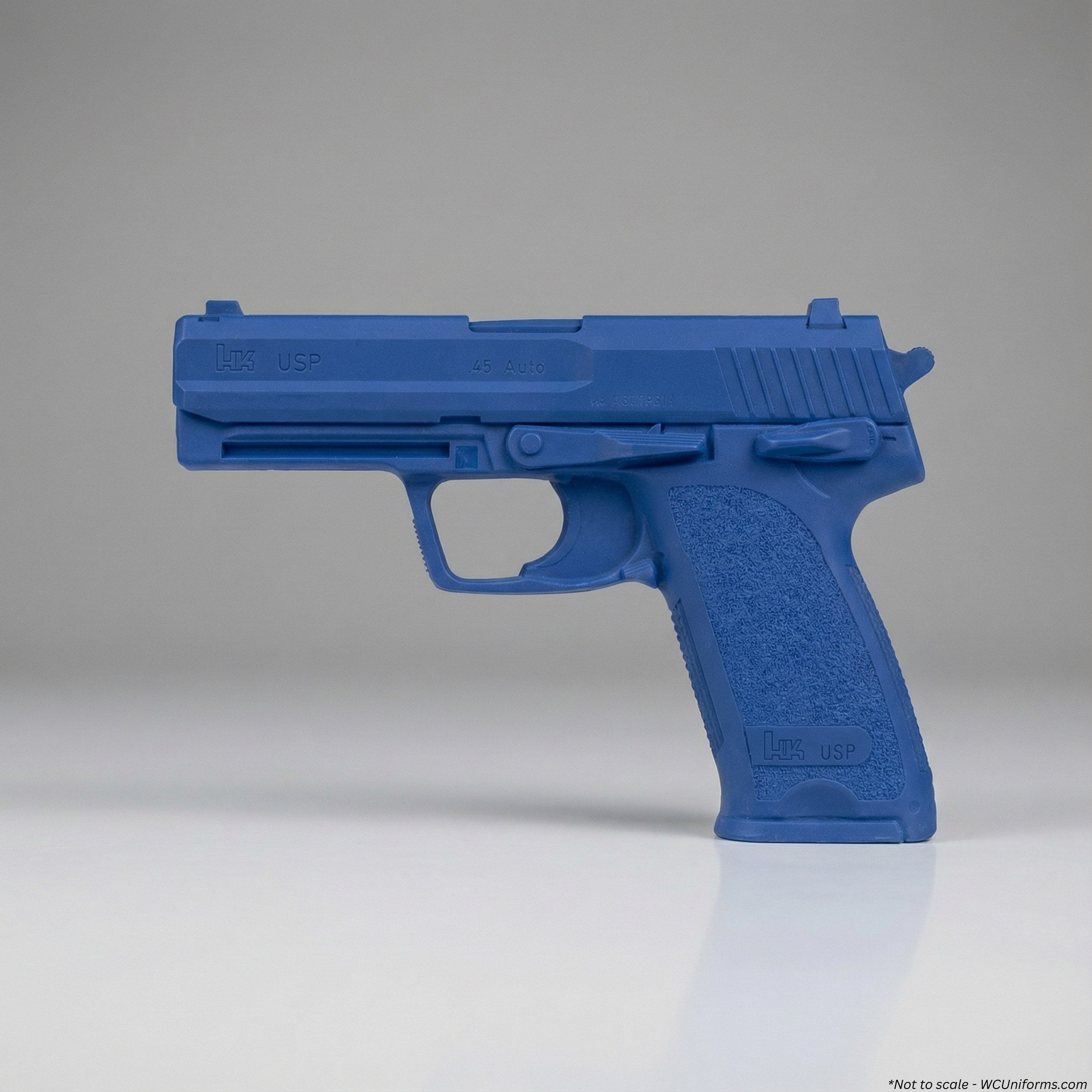 Blue plastic gun on a reflective surface with a gray background