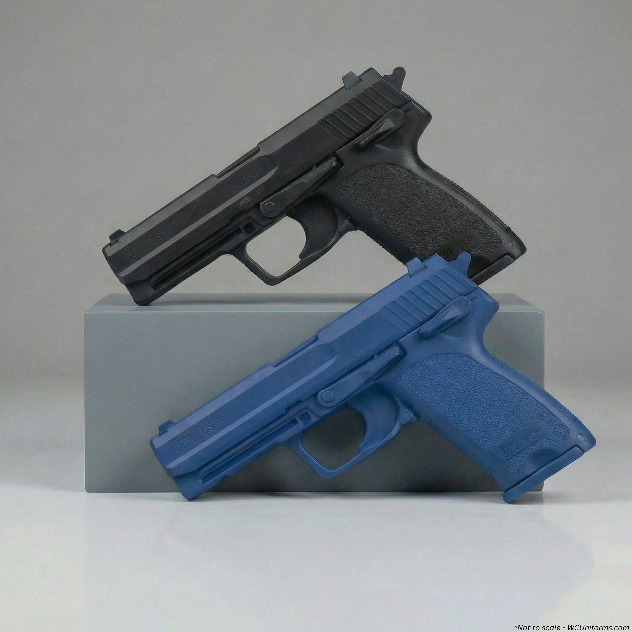 Black and blue handguns on a gray block with a plain background