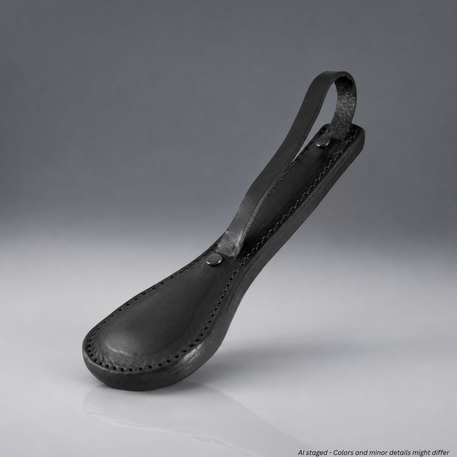 Black leather sap impact tool on a gray background