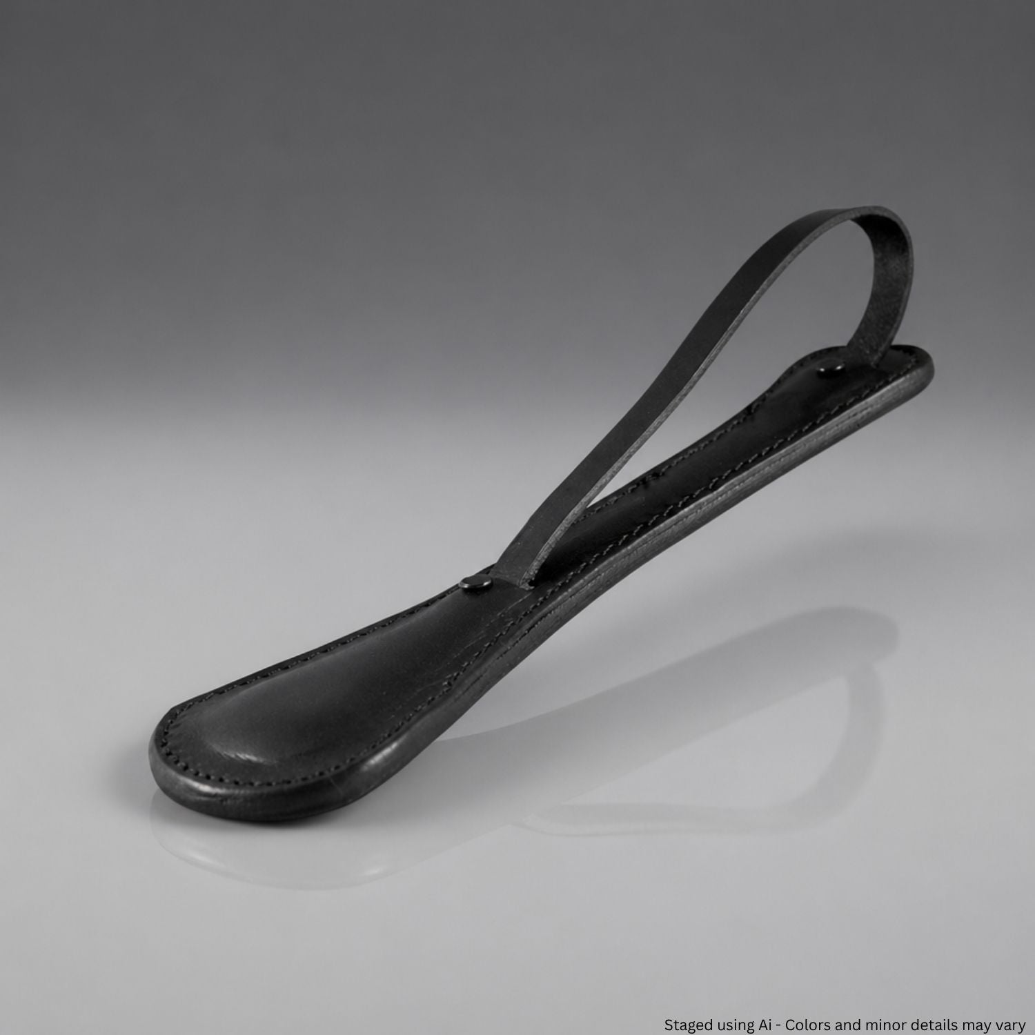 Black leather sap with a hand strap on a gray background