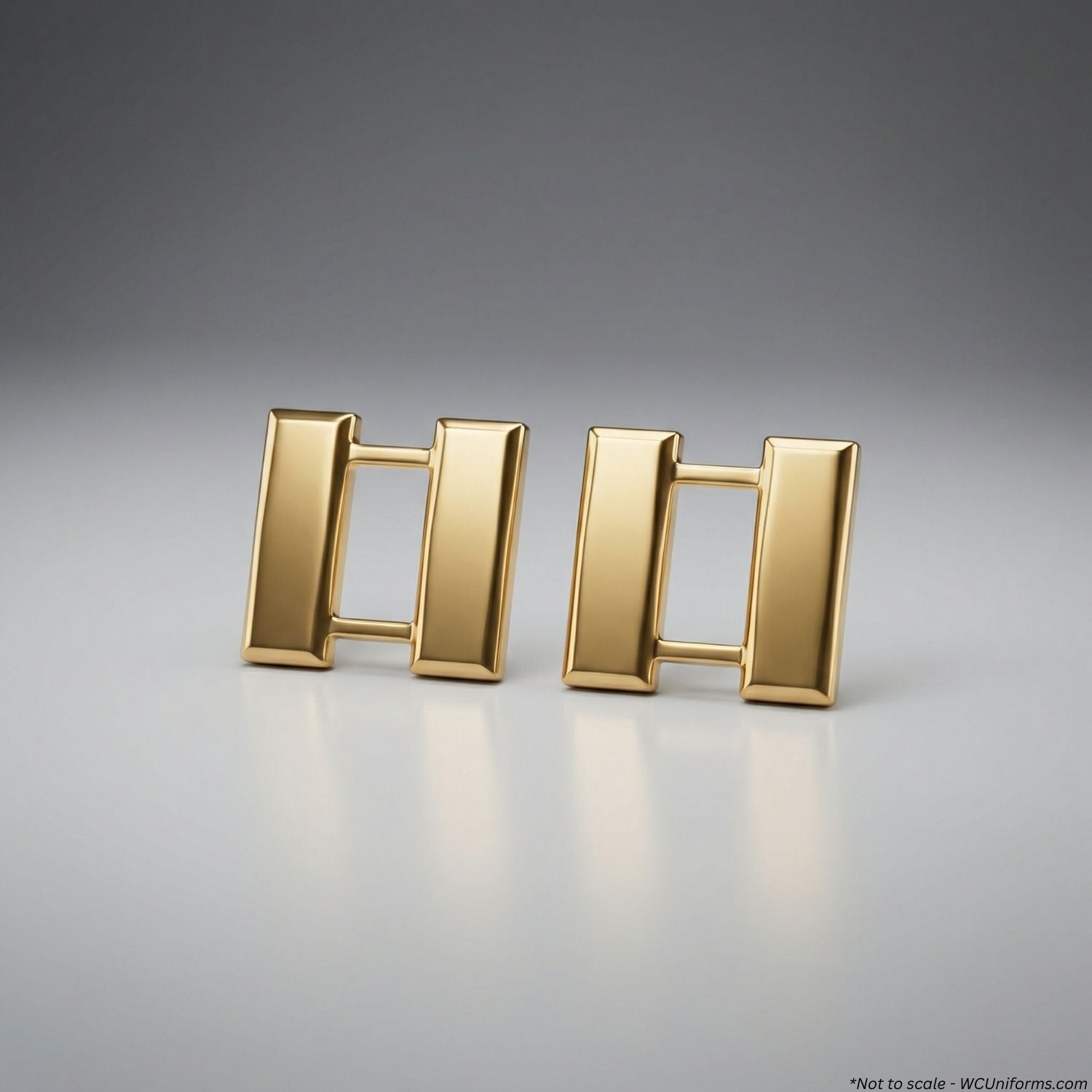 Pair of gold Captain's pins on a gray background