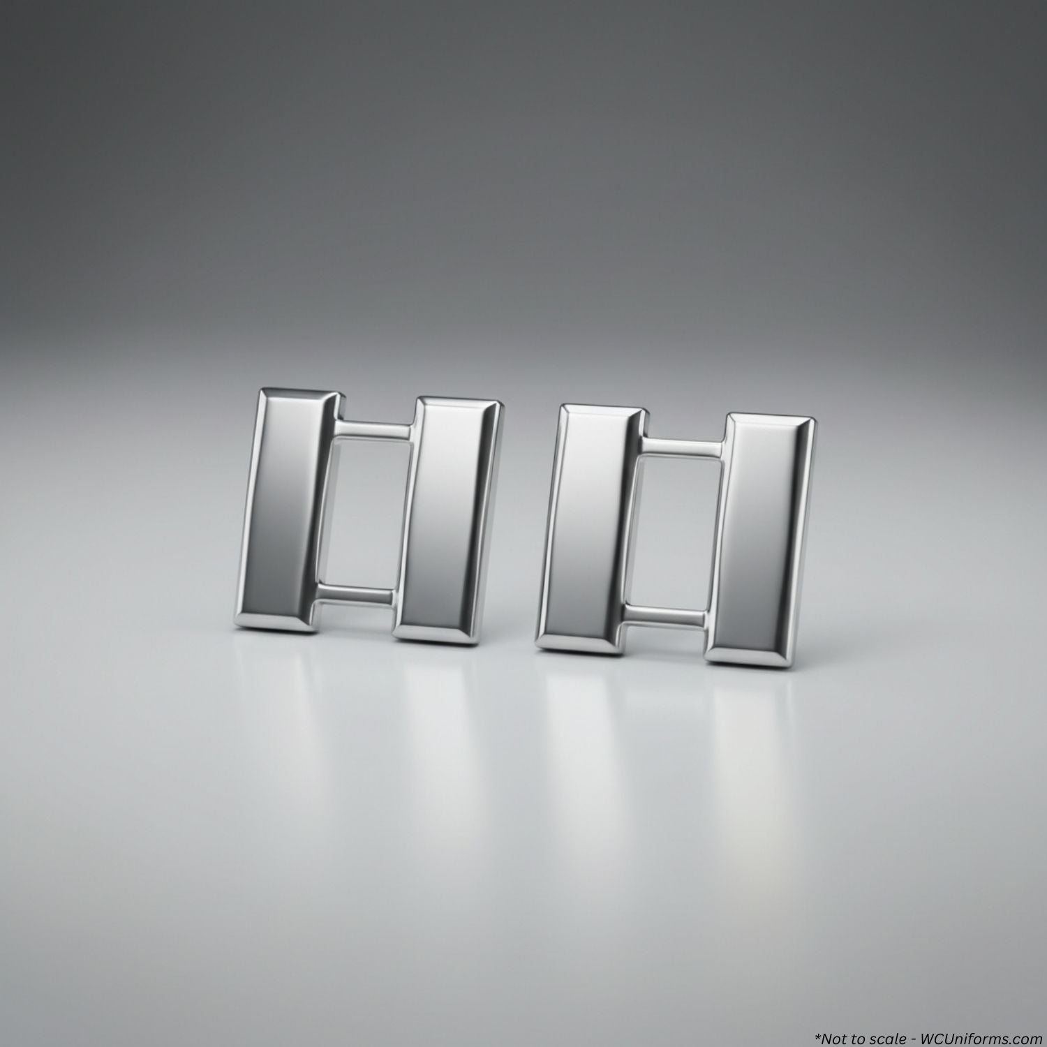 Pair of silver Captain's pins on a gray background