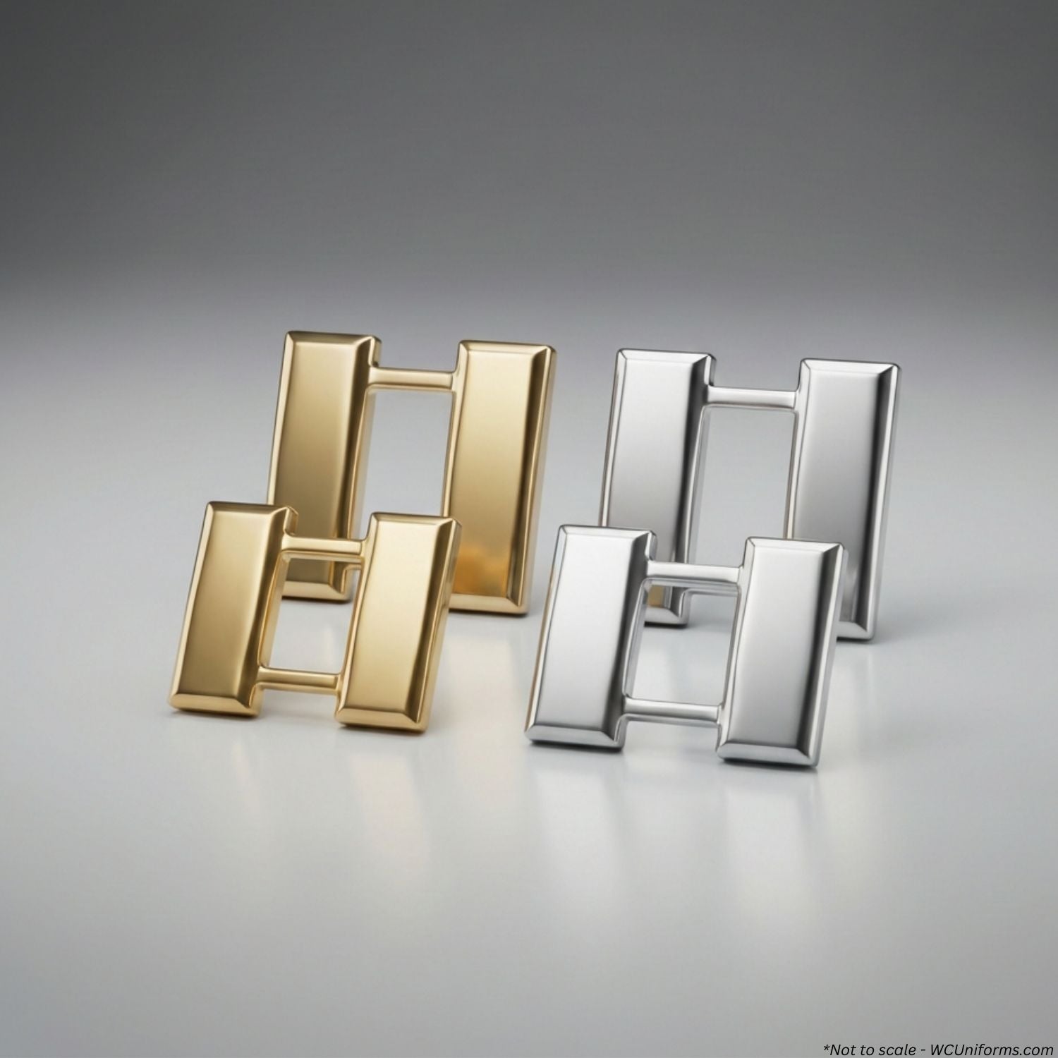 Gold and silver Captain's rank pins on a gray background