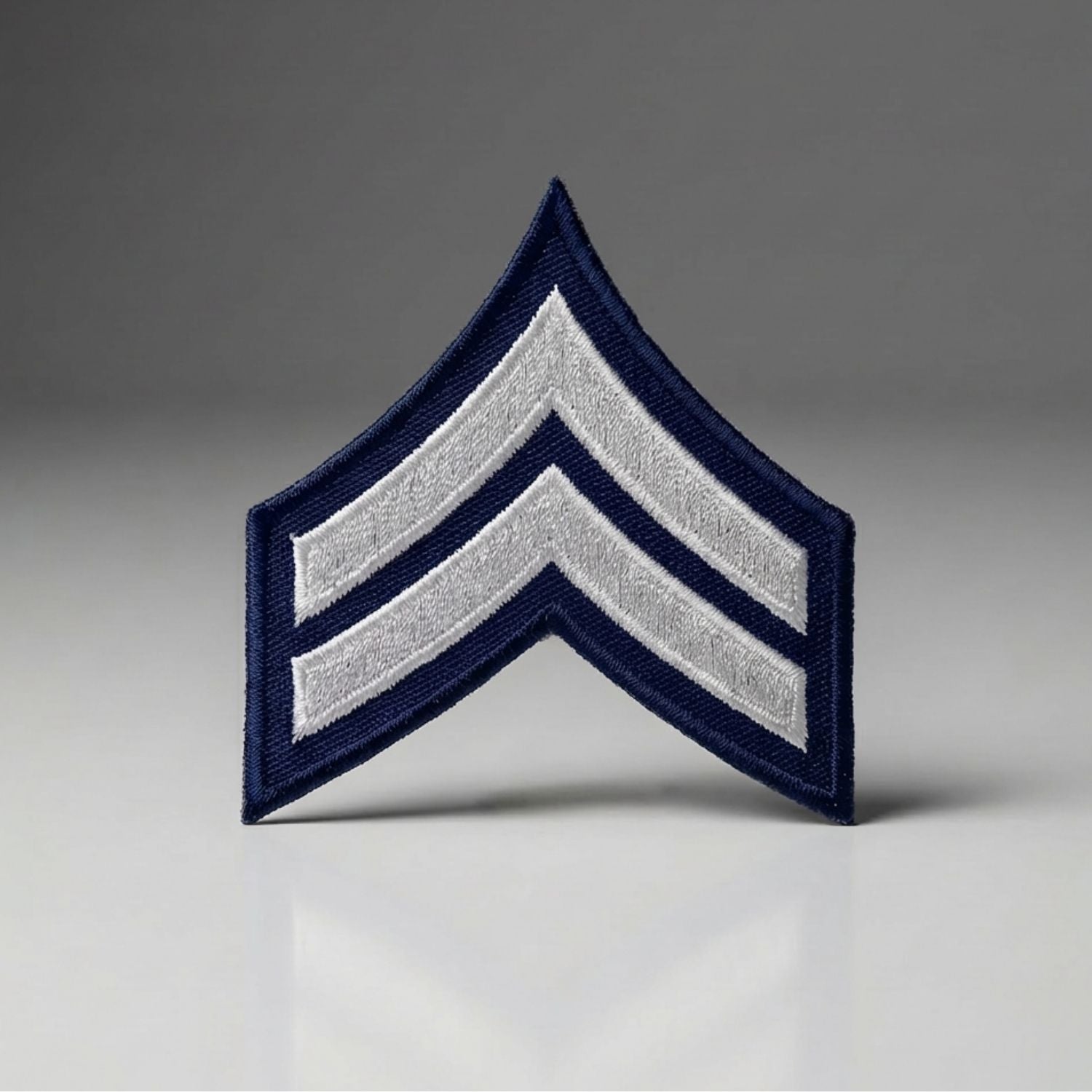 Navy and silver military rank insignia patch on a gray background