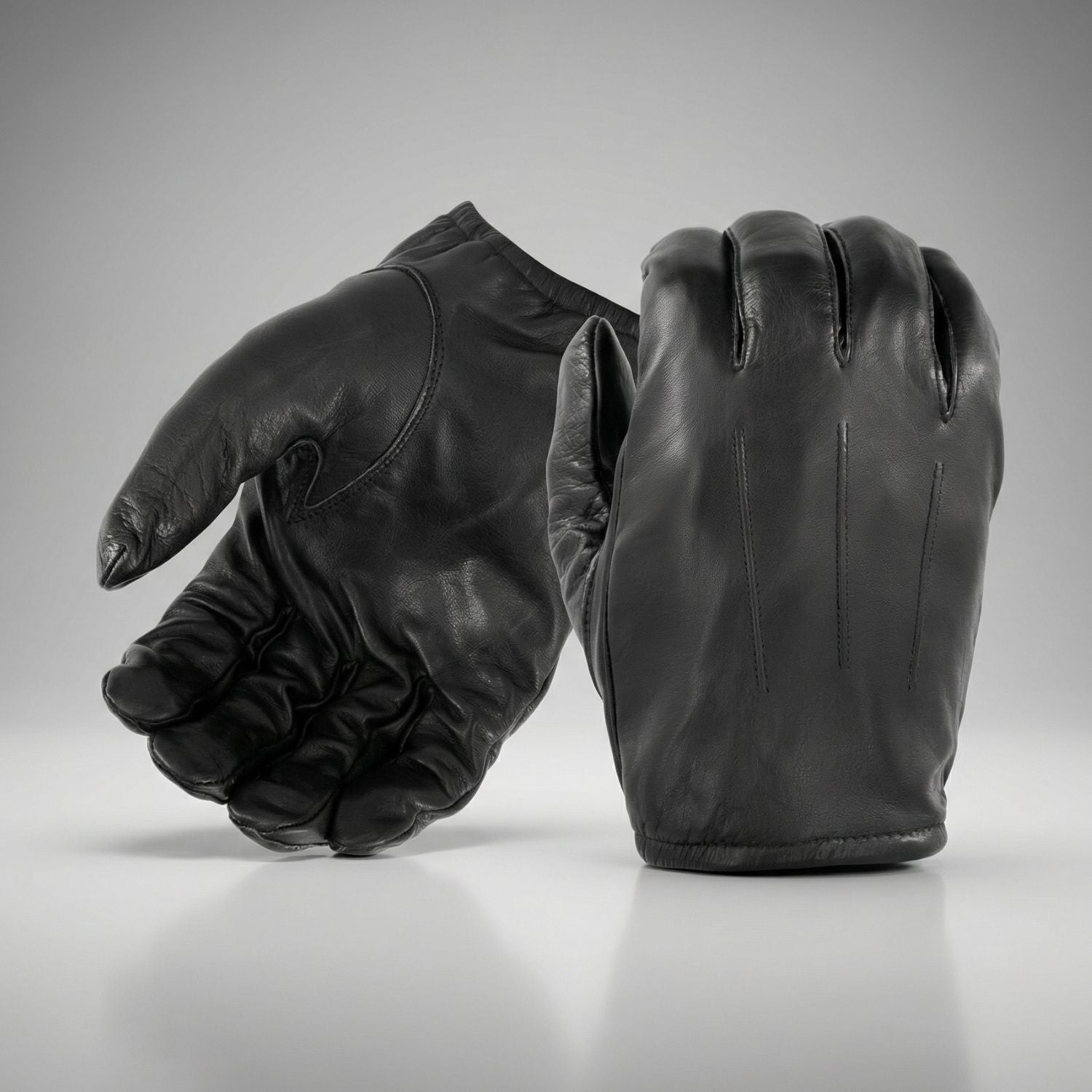 Pair of black leather gloves on a gray background