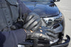 A police officer wearing leather driving gloves with a patrol car in the background