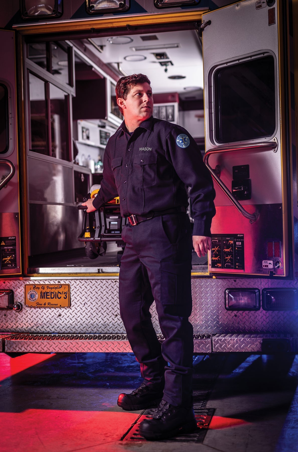 Medic standing in front of a fire truck with a cityscape background