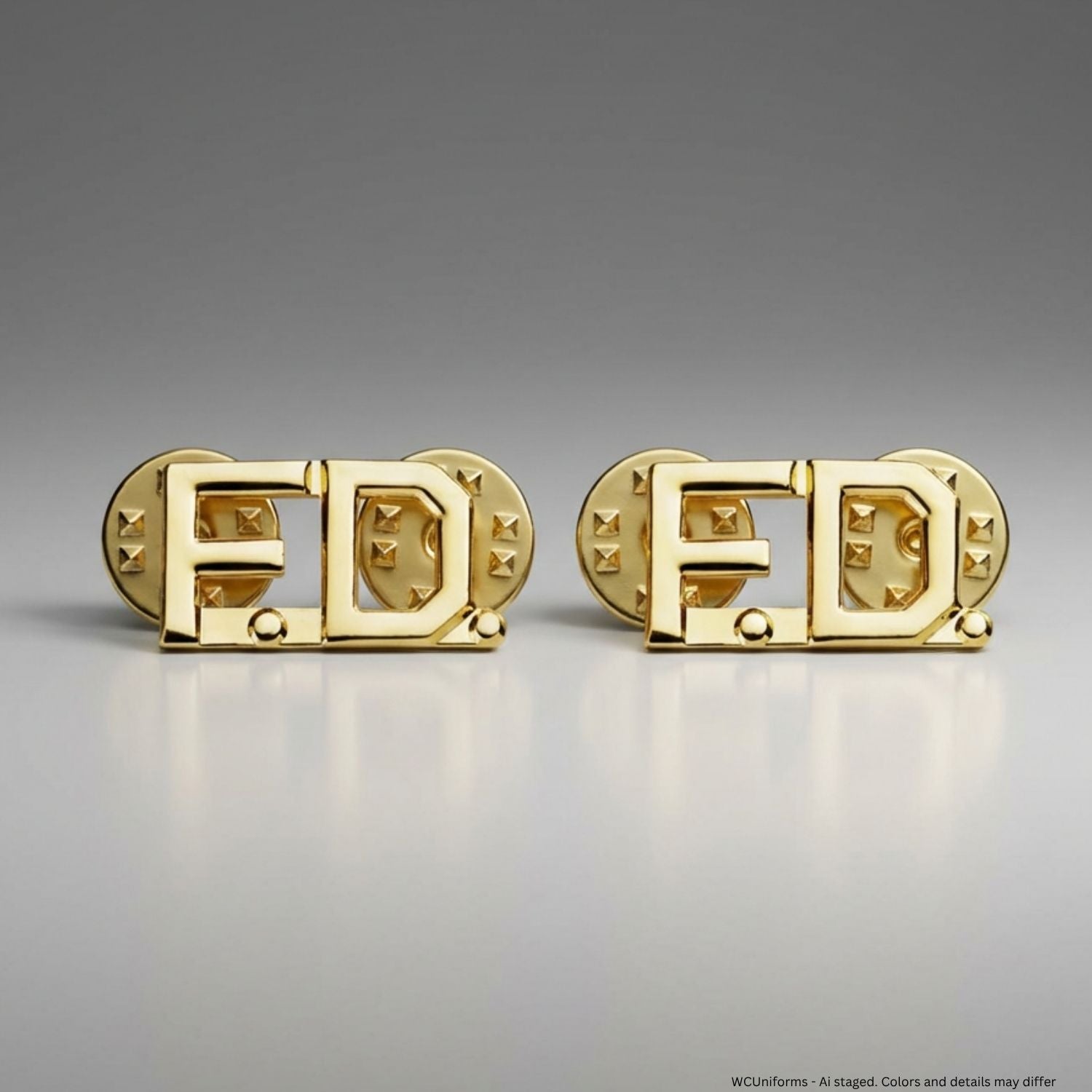 Gold collar pins with 'F.D.' design on a gray background