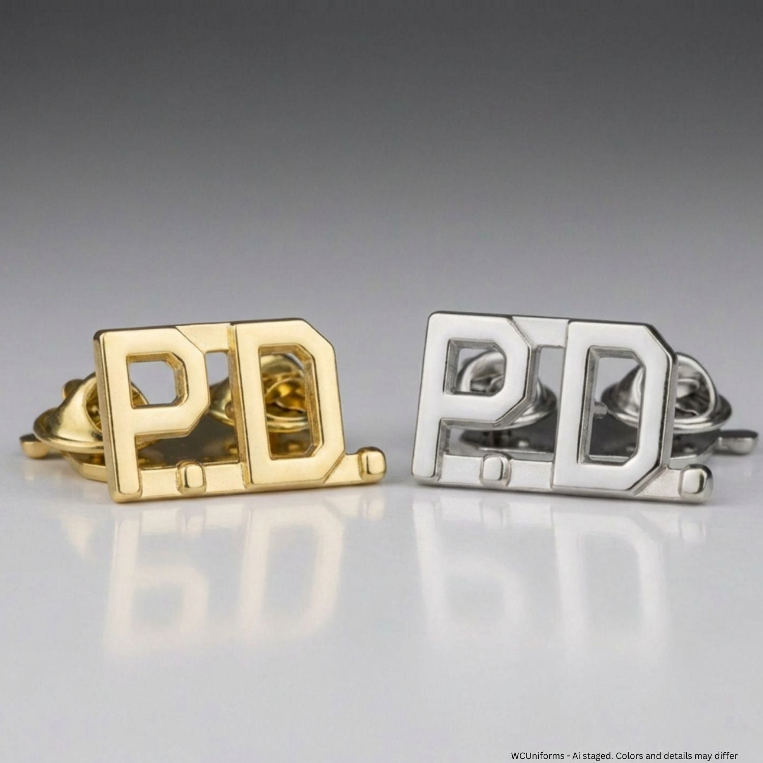 Gold and silver Collar pins with 'P.D.' initials on a reflective surface.