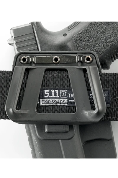 Close-up of a tactical belt with a gun holster featuring 5.11 Tactical branding.