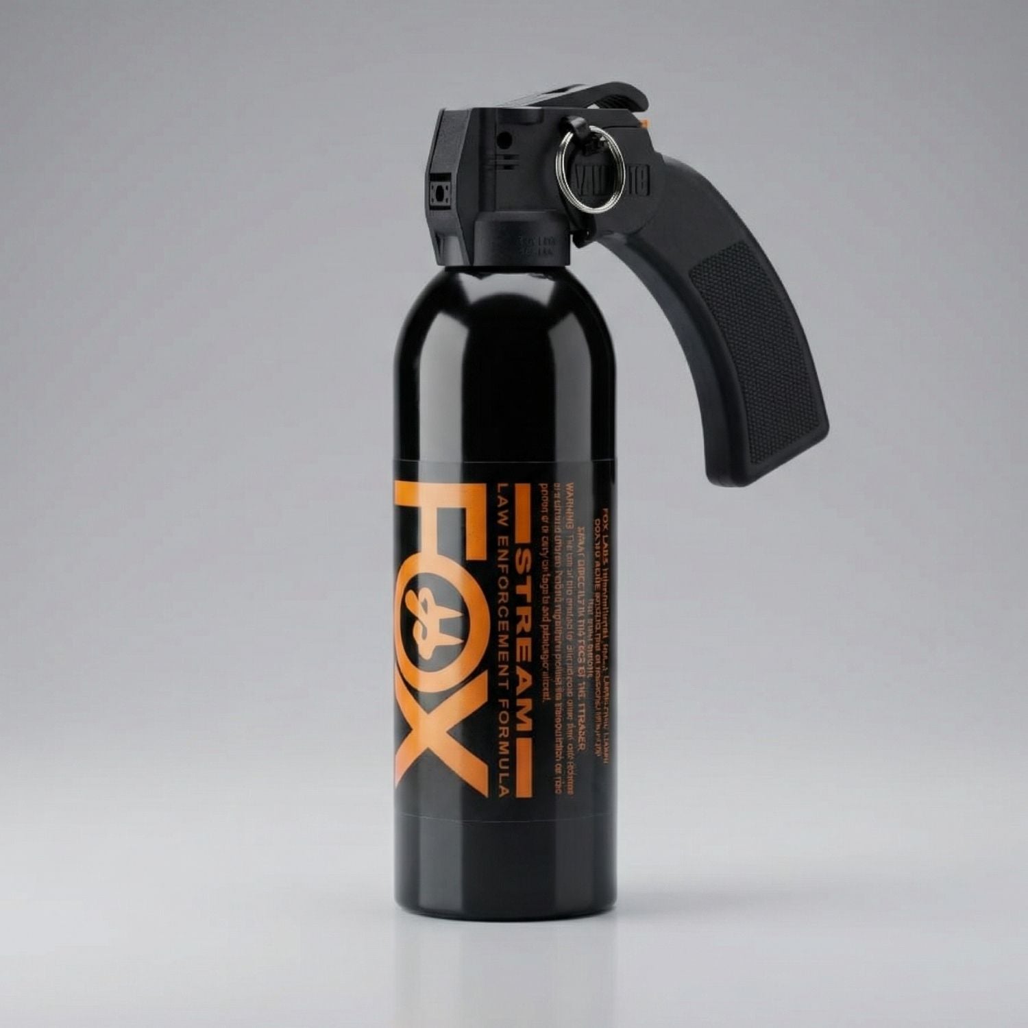 Black pepper spray canister with 'FOX' branding on a gray background