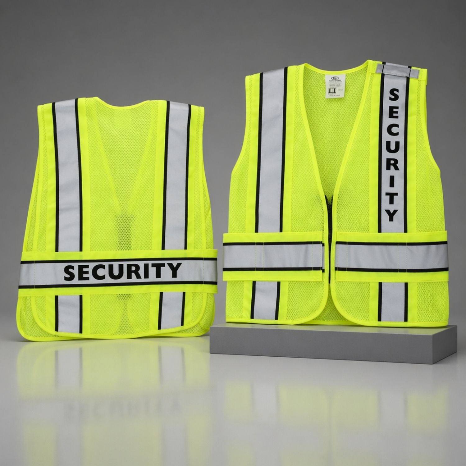 Two yellow security vests with reflective stripes on a gray background