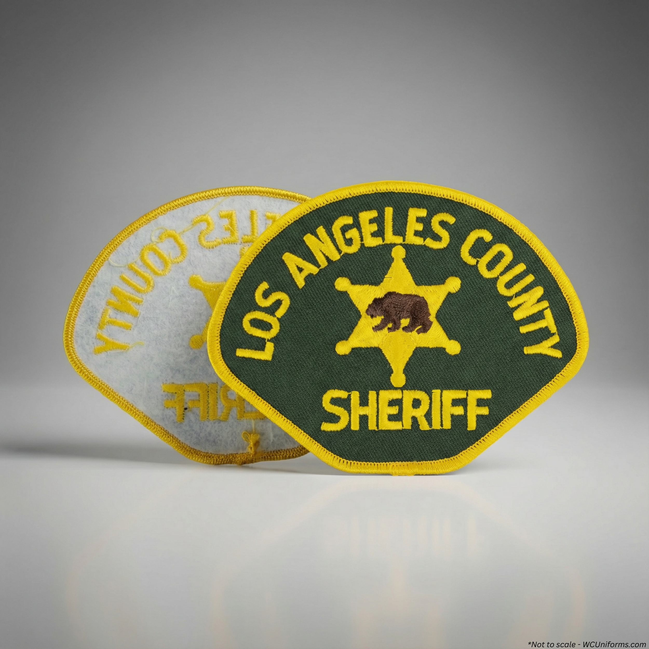 Official LASD uniform shoulder patch in green and gold. Sew-on design. Sold individually. on a gray background
