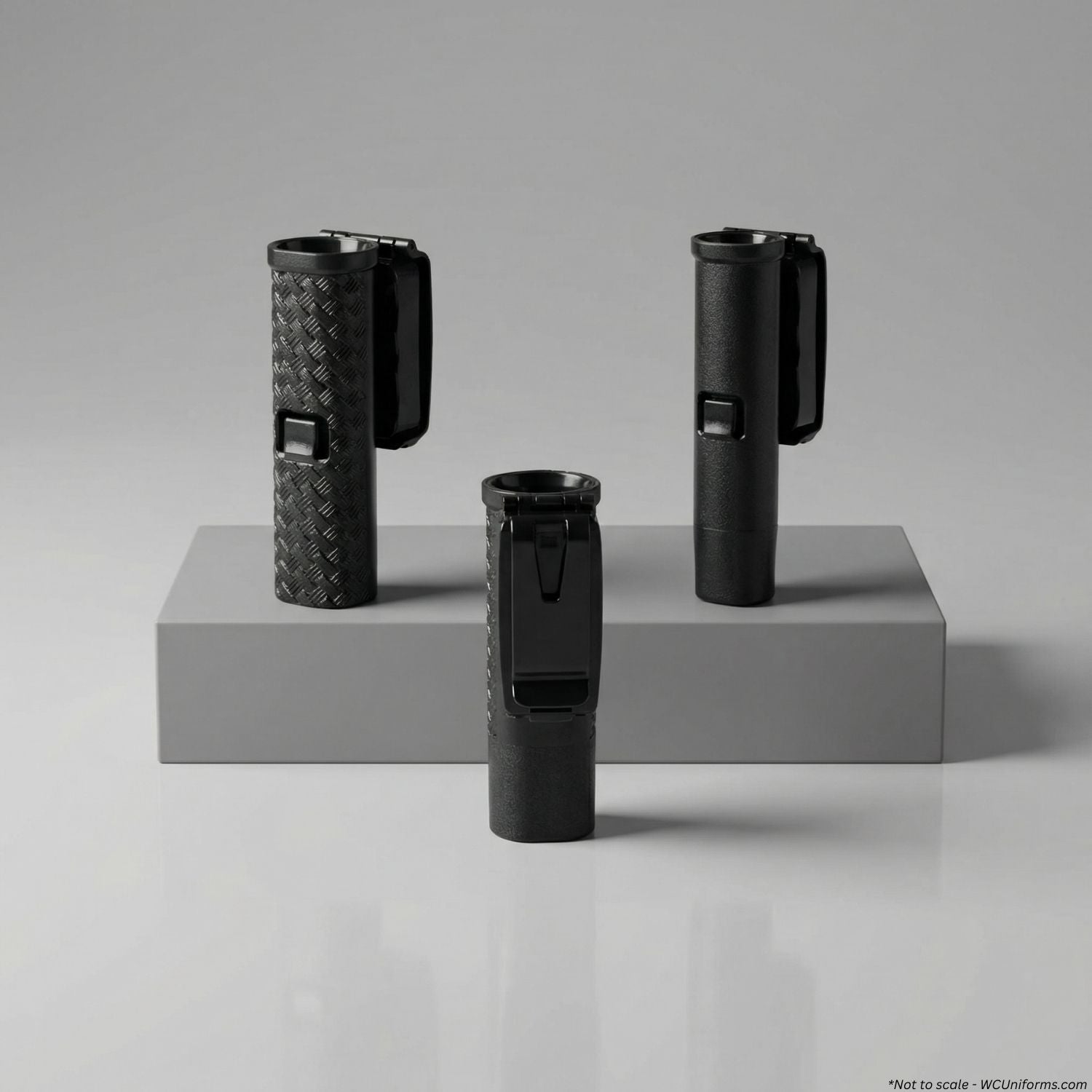 Three black expandable baton holders on a gray platform with a gray background
