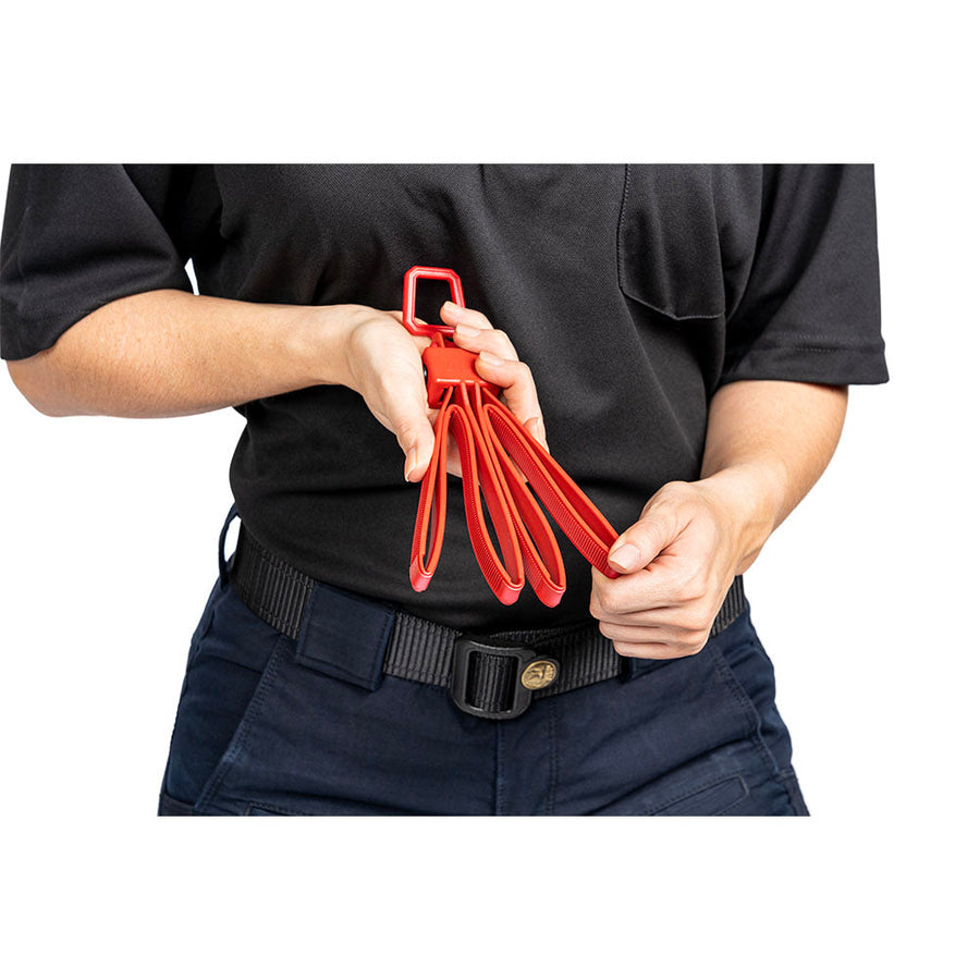 Person holding a set of red training handcuffs against a white background