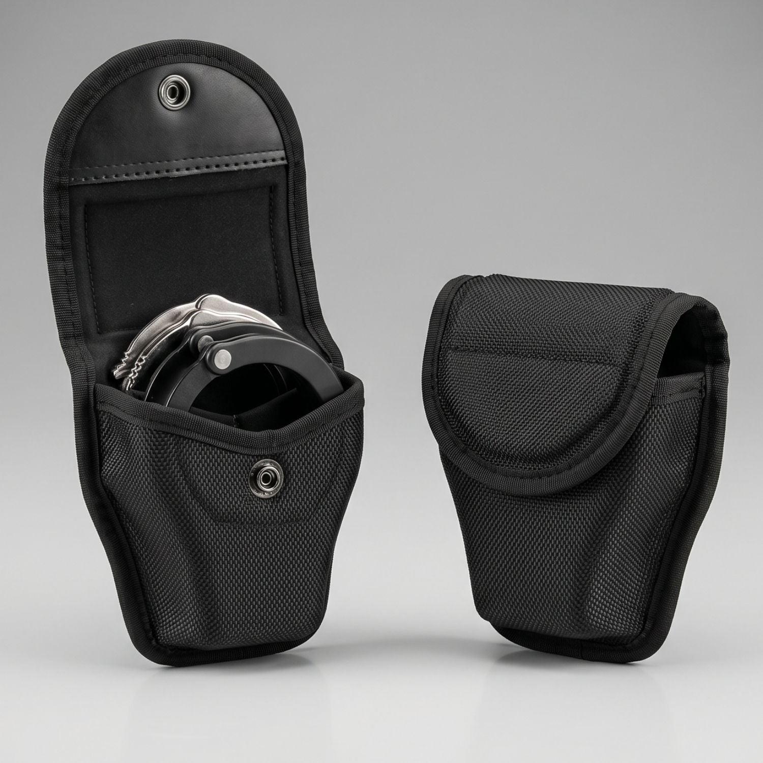 Two Black tactical handcuff pouches on a gray background